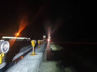 A ground-level view of a pathway at night, illuminated by several airfield lighting.